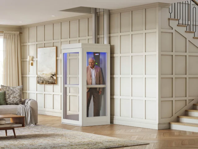 A man standing inside a home elevator