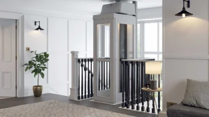 Pollock Home Elevator at the second floor landing blending with dark railing and wooden floor