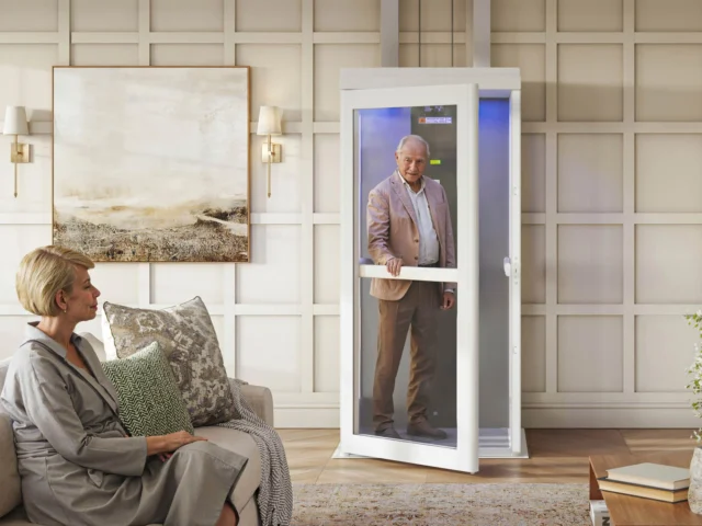 A man opening the door and entering a place where a lady is sitting