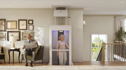Older woman riding in her elevator with her husband sitting on the couch with a newspaper