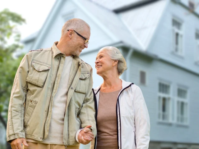 Senior couple in springtime jackets outside, smiling at each other