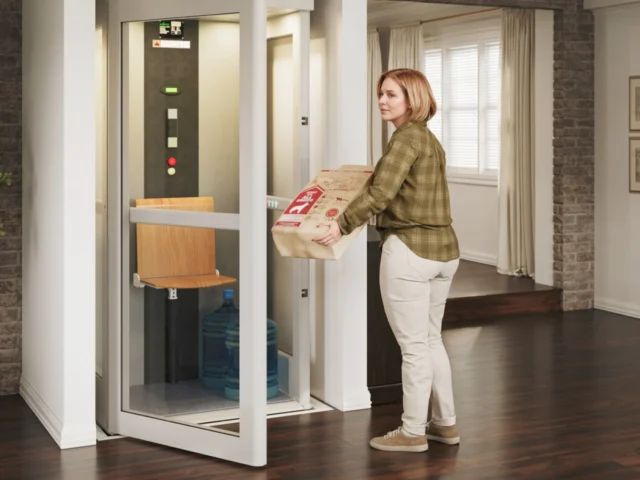 Woman carrying a heavy package into her Pollock elevator.