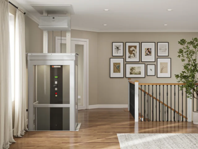A home elevator is rising to the second floor of a residence, located near the top of the stairs.