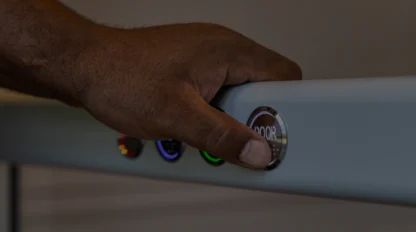 A dimly lit photo zeros in on a man's hand on a gab bar with four buttons. His thumb presses one.